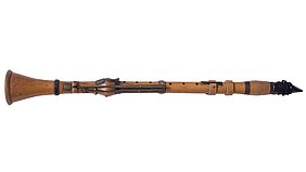 Eine historische Klarinette aus hellem Holz mit mehreren Metallklappen und -ringen liegt waagerecht auf weißem Hintergrund. Das Instrument zeigt eine leicht konische Form mit trichterförmigem Schallbecher links und einem Mundstück mit aufgebundenem Blättchen rechts. Die Oberfläche wirkt glatt, die Mechanik ist schlicht gehalten.